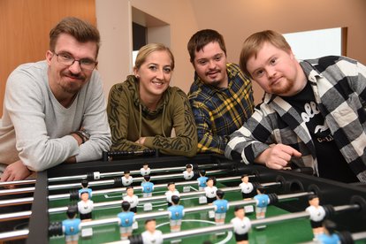 Menschen vor einem Kicker