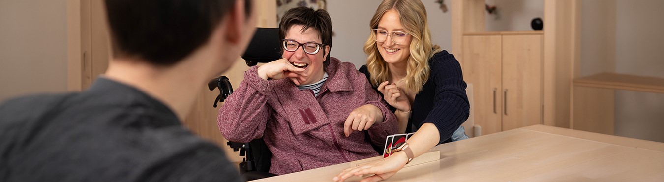 Zwei Frauen spielen Karten und lachen